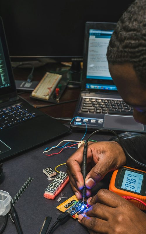 African American man at a desk working on a circuit board, diversity in tech, diversity in STEM