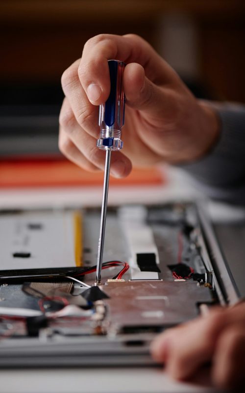 Technician Using Screwdriver for Broken Computer Repair